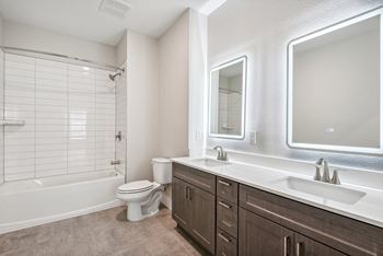 a bathroom with a toilet sink and shower and a mirror at The Virginia, Seguin, 78155